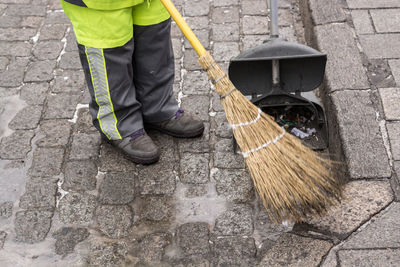 Low section of man cleaning footpath
