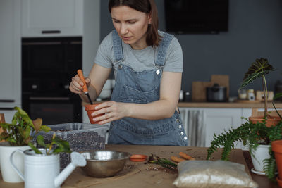 Portrait of young woman preparing food at home