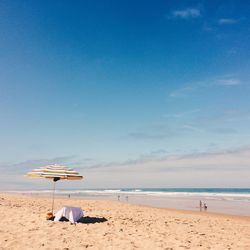 Scenic view of beach against blue sky