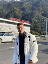 Portrait of young man standing in car