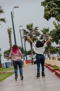 Rear view of friends walking on footpath