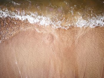 Full frame shot of wet glass on beach