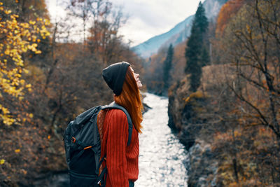 Rear view of person standing on rock against trees