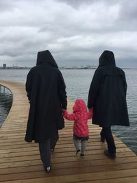 Rear view of people walking on beach