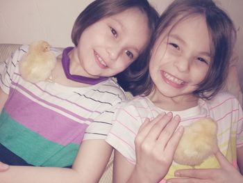 Close-up portrait of smiling girls with chicks