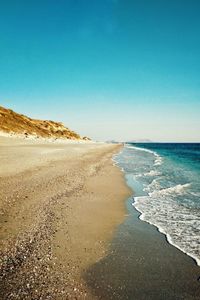 Scenic view of beach against clear blue sky