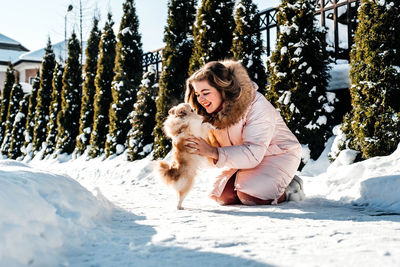 Young woman with dog in snow