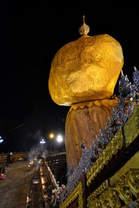 Statue against illuminated building at night