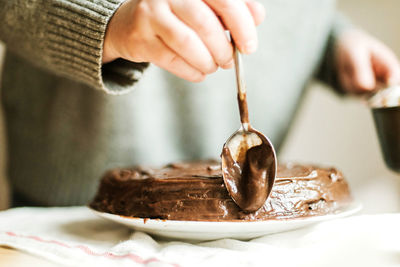 Close-up of hand holding ice cream on table