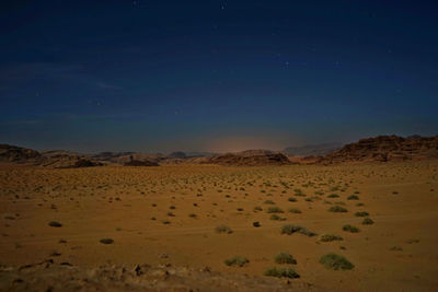 View of barren landscape with mountains at night