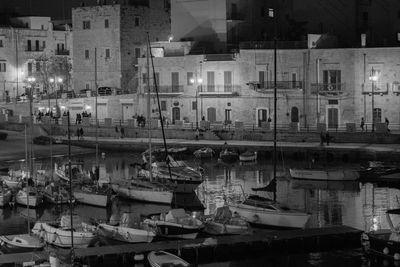 Boats moored in harbor at night