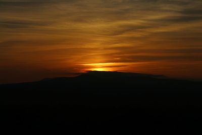 Scenic view of silhouette mountain against sky at sunset