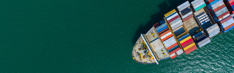 High angle view of boat sailing on sea against building