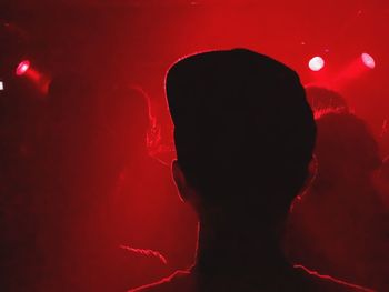 Rear view of silhouette man against illuminated red light