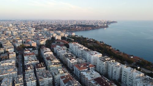 High angle view of townscape by sea against sky