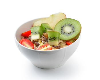 Close-up of fruits in bowl against white background