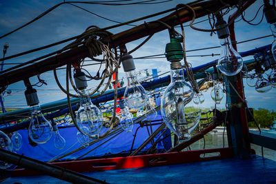 Fishing boats moored at harbor against blue sky