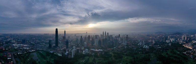 Panoramic view of city buildings against sky during sunset