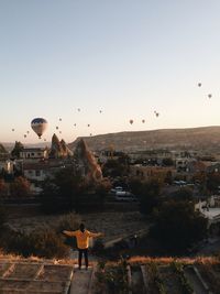 People in city against clear sky during sunset