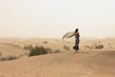 Man on desert against clear sky