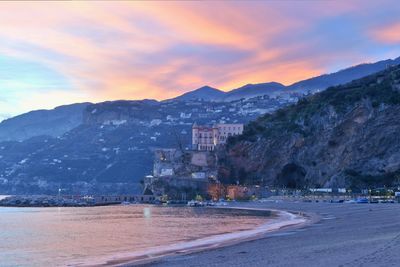 Scenic view of sea and mountains against sky during sunset