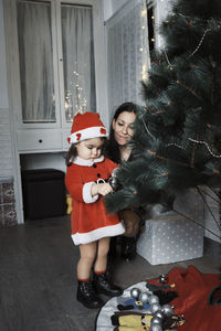 Full length of girl with christmas tree