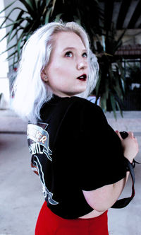 Young woman with dyed hair looking up