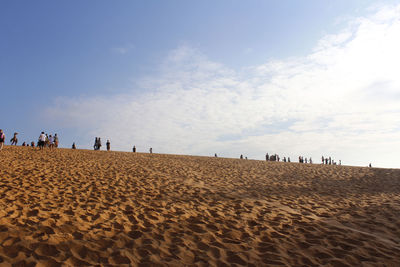 People at beach against sky