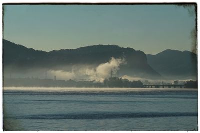 View of calm sea against mountain range