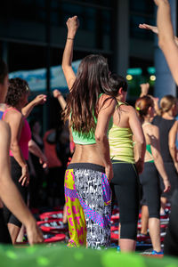 Rear view of women dancing at music concert