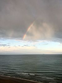 Scenic view of rainbow over sea against sky