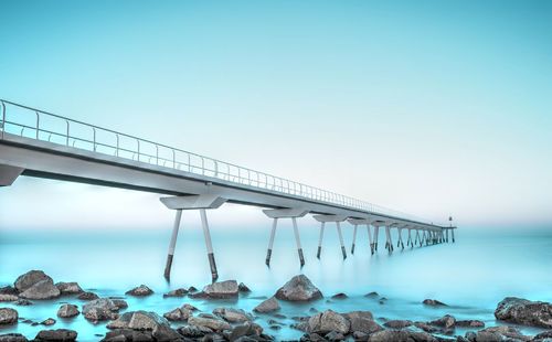 Pier over blue sea against sky