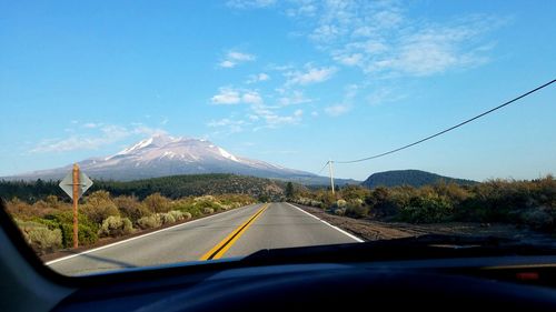 Road by mountains seen through car windshield