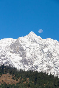 Scenic view of snowcapped mountains against clear blue sky