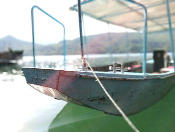 Close-up of boat moored on shore against sky