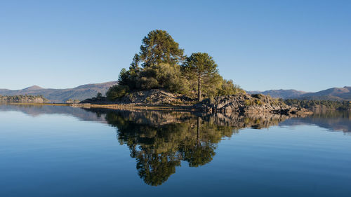 Scenic view of lake against clear blue sky
