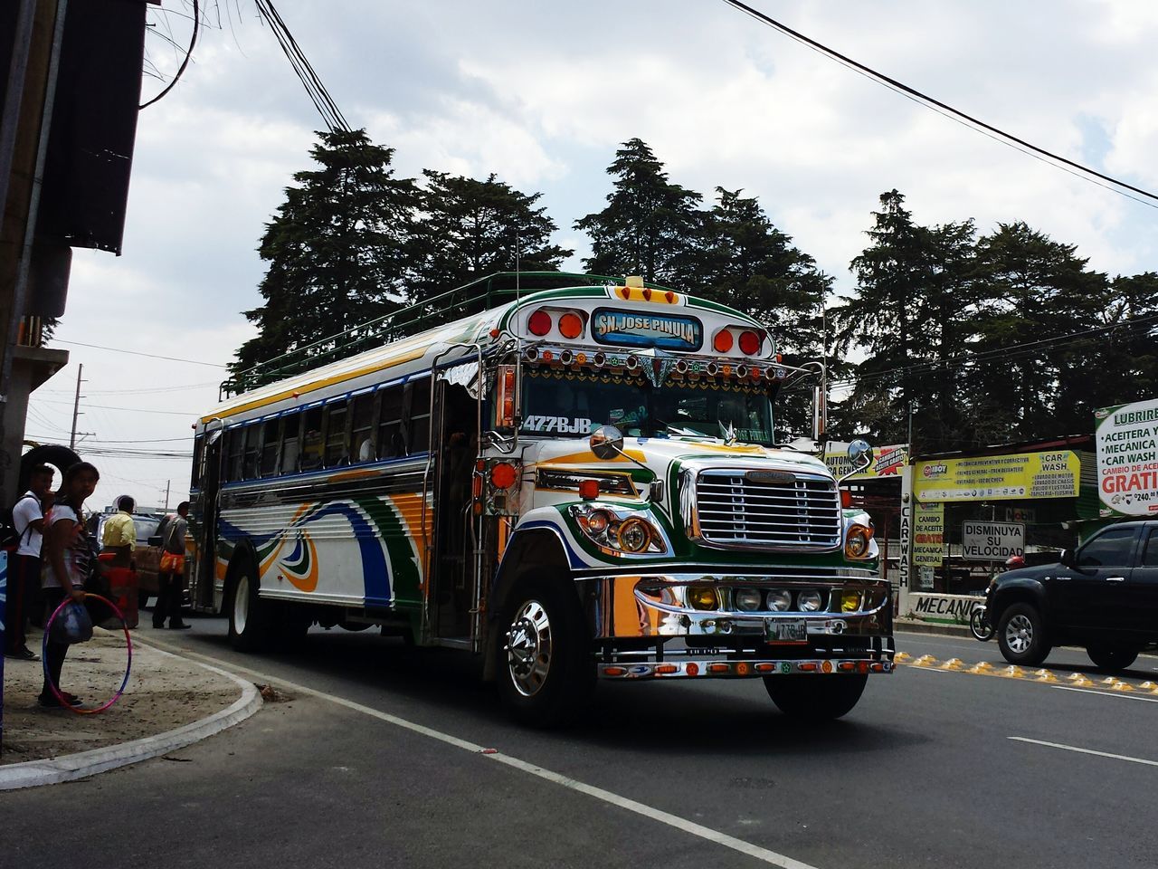 transportation, mode of transport, land vehicle, sky, street, architecture, built structure, building exterior, road, car, men, public transportation, travel, city, cloud - sky, railroad track, tree, incidental people, on the move