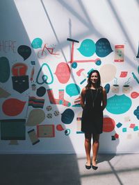 Young woman standing in front of wall