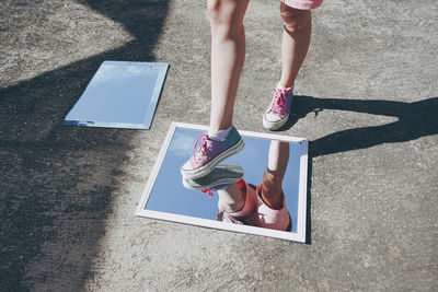 Woman stepping on mirrors wearing canvas shoes