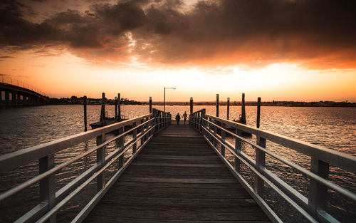 Pier over sea against sky during sunset