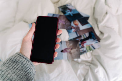 Midsection of person using mobile phone on bed