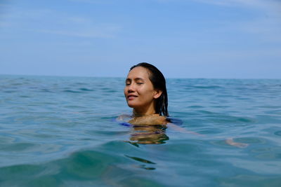 Portrait of woman swimming in sea against sky