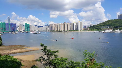 Scenic view of sea by cityscape against sky