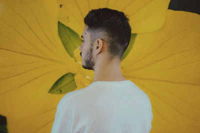 Rear view of man by yellow flower