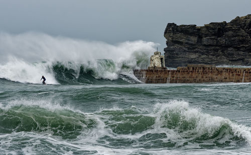 A lone surfer against a large wave.