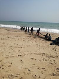 People on beach against sky