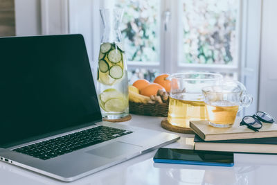 Healthy breakfast laptop and phone on table. natural meal and drink at work in remote office