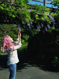 Full length of girl standing against tree