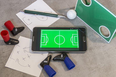 High angle view of mobile phone bu ball and objects on table