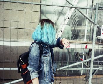 Rear view of woman standing against window